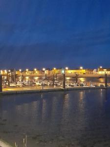 a view of a parking lot with a harbor at night at Meublé bord de Mer in Gravelines