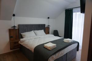 una camera da letto con un letto e due asciugamani di Pensiunea Cascada a Borşa