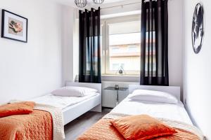 two beds in a bedroom with a window at Willa Bliźniak 2 - Wyżywienie wliczone w cenę in Karwia