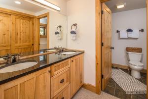uma casa de banho com 2 lavatórios e um WC em Powder Ridge Cabin | 6 Chief Gull em Big Sky