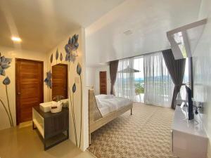 um quarto com uma cama e uma grande janela em Arya Exclusive Villa 
