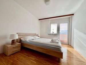 Habitación blanca con cama y ventana en Hiša Naomi Sofia, en Bled