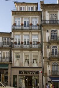 un edificio alto con maniquíes blancos en las ventanas en Clerigos View, en Oporto