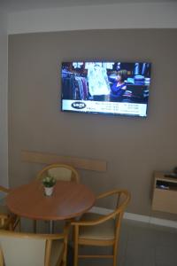 a table and chairs with a television on a wall at Villa Lyss Apartment 1 in Mellieħa