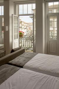 a bedroom with a large bed and a large window at Clerigos View in Porto
