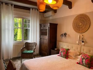 1 dormitorio con 1 cama, 1 silla y 1 ventana en La Marjolaine, en Juan-les-Pins