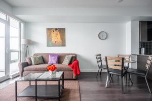a living room with a couch and a table at Modern Dunfield Ave Condos by GLOBALSTAY in Toronto