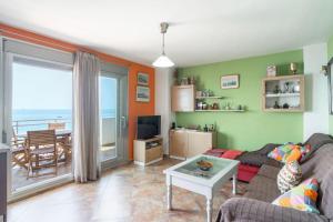a living room with a couch and a table at Ático en primera línea de playa con vistas al mar in Cala del Moral