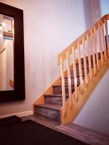een trappenhuis met een spiegel en een houten trap bij Condo sur 2 niveaux avec magnifique vue sur la montagne in Stoneham