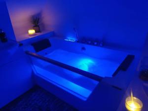 a blue room with a bath tub with lights in it at Sunny Family Residence with parking. Jacuzzi bath perfect for relaxing and unwinding in Kent +21 photos