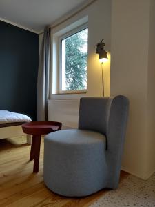 steenkamp•studio Auntys' Chamber في هامبورغ: غرفة معيشة مع كرسي ونافذة