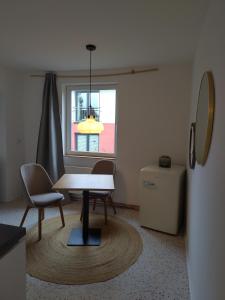 steenkamp•studio Auntys' Chamber في هامبورغ: غرفة مع طاولة وكراسي ونافذة