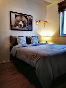 een slaapkamer met een groot bed met een foto van een beer bij Condo sur 2 niveaux avec magnifique vue sur la montagne in Stoneham