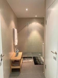 a bathroom with a shower and a wooden table at Private room with work space near Zurich in Adliswil