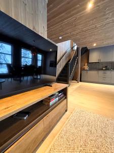 a living room with a large entertainment center and a staircase at Norebu - Norefjell in Noresund