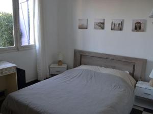 una camera con un letto e due tavoli e una finestra di VILLA face à la plage avec terrasse et jardin a Narbonne