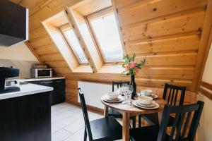 a kitchen and dining room with a table and chairs at Forest Home Zakopane by LoftAffair in Zakopane