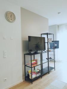 a shelf with a tv and a clock on a wall at Ferienwohnung Martinsesch in Bad Schussenried