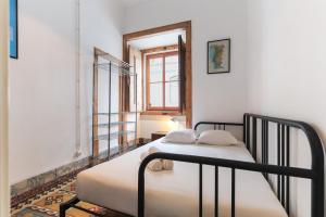 2 łóżka w małym pokoju z oknem w obiekcie Downtown Vintage Suites by Homing w Lizbonie