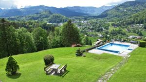 uma casa com piscina numa colina relvada em Ferienwohnungen Angerer Kederlehen em Berchtesgaden