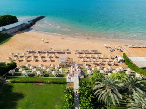 BM Beach Hotel في رأس الخيمة: اطلالة جوية على شاطئ مع مظلات