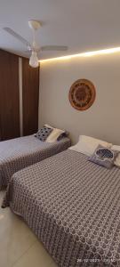 duas camas sentadas uma ao lado da outra num quarto em Paraíso Peracanga - Bacutia em Guarapari