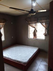 ein großes Bett in einem Zimmer mit Fenster in der Unterkunft Abakidoye Lodge in Ilora