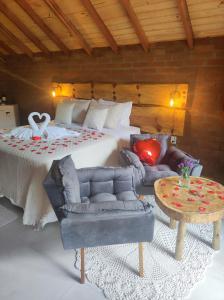 a bedroom with a bed and a couch and a table at Pousada das Castanheiras in Monte Verde