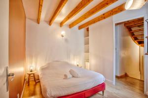um quarto com uma cama branca e um banco vermelho em The castle house em Caen