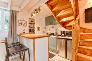 a kitchen with wooden ceilings and a wooden staircase at The castle house in Caen