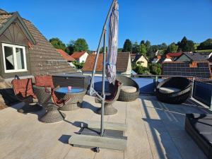 eine Terrasse mit einem Tisch, Stühlen und einem Sonnenschirm in der Unterkunft Weitblick in Öhningen