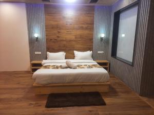 a bedroom with a large bed with wooden walls at Manali mountain River Hotel & Resort in Manāli