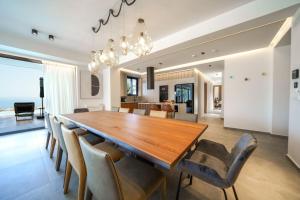 a dining room with a large wooden table and chairs at Nivo Luxury Villa in Giannoudi