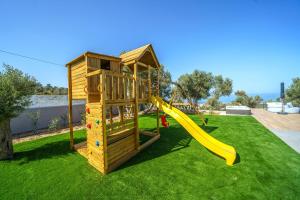 a playground with a slide in a yard at Nivo Luxury Villa in Giannoudi