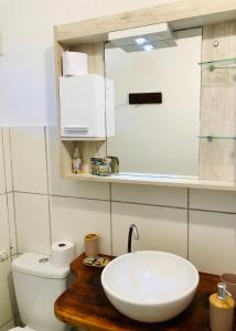 La salle de bains est pourvue d'un lavabo blanc et de toilettes. dans l'établissement Pousada Tangerina, à Icaraí