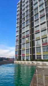 a large apartment building with water in front of it at Husfa Mahkota Valley Studio Suite in Kuantan