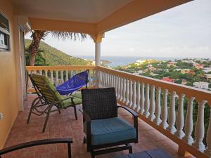 een balkon met 2 stoelen en een parasol bij Apartment and Studio with privacy and wonderful view. in Dawn Beach