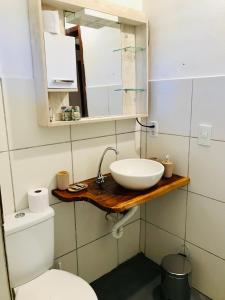 uma casa de banho com um lavatório e um WC em Pousada Tangerina em Icaraí