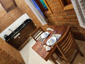 een uitzicht op een houten tafel en stoel in een kamer bij Pousada das Castanheiras in Monte Verde