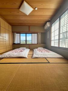 two beds in a room with two windows at 吉祥莊 in Takayama