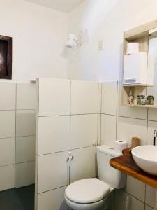 een witte badkamer met een toilet en een wastafel bij Pousada Tangerina in Icaraí