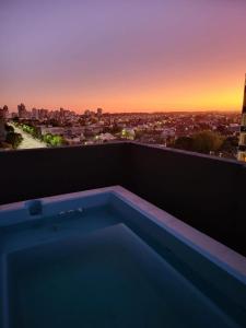 a hot tub on a balcony with a view of a city at NECOCHEA Centro MONOAMBIENTE PARA 2 PERSONAS in Necochea