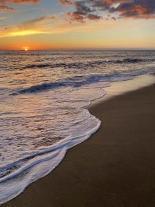 um pôr do sol na praia com o oceano em NECOCHEA Centro MONOAMBIENTE PARA 2 PERSONAS em Necochea