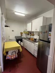 eine Küche mit einem gelben Tisch und einem Kühlschrank in der Unterkunft Casa Central, Amplia y Cómoda in Antofagasta