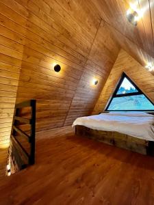 伊茲基的住宿－Тихий куточок，木制客房的一张床位,设有窗户