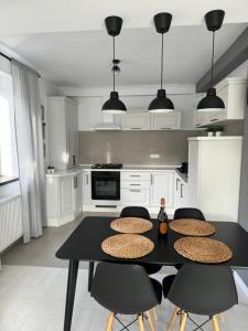 a kitchen with a black table with chairs and a stove at HCT Sinaia Apartment in Sinaia +16 photos