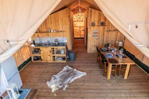 a room with a table and a kitchen in a tent at Pérola de Sandy in Paderne