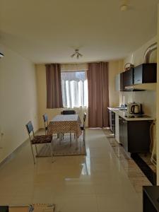 a living room with a table and a kitchen at Villa Kalina Apartments in Bansko