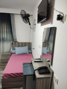 a room with two beds and a desk and a mirror at فندق أجياد Agyad Hotel in Asyut