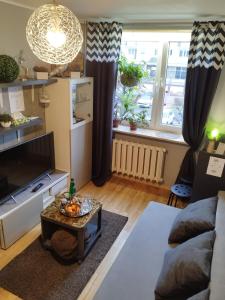 Niewielki pokój dla jednej osoby lub pary. في وارسو: غرفة معيشة مع أريكة وطاولة